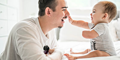 Smiling baby touching dad’s face