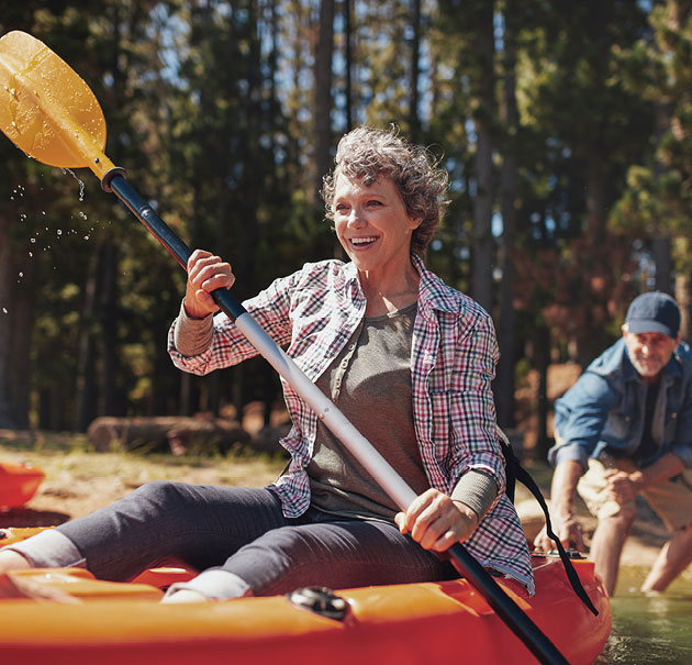 Happy woman shoves off on a kayak