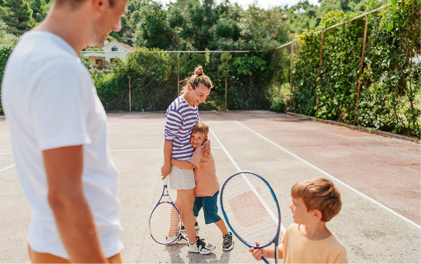 A family having fun on a tennis court.