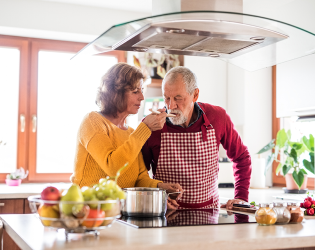 A senior couple cooks together in their kitchen