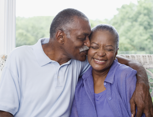 Older african-american couple snuggling on couch