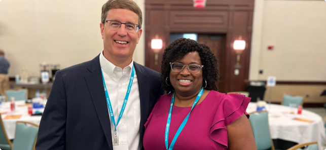 Two Protective teammates smiling at a supplier diversity event.
