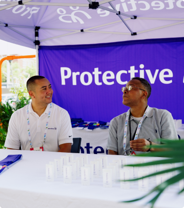 Two Protective teammates volunteer in a booth at The World Games.