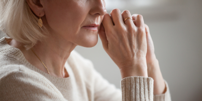 Bereaved older woman thoughtfully considering her emotional and financial needs.