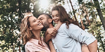 Young couple with a small child hugging and feeling happy that they have life insurance. 