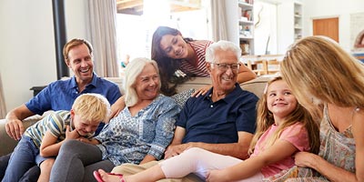 Multi-generational family sitting together on a couch.