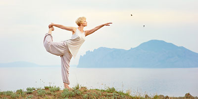Woman doing yoga while overlooking a picturesque scene.