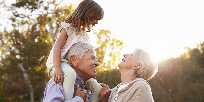 Grandparents playing with their granddaughter outside