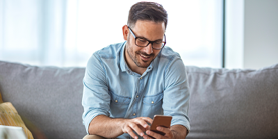 Man sitting on couch looking at his phone