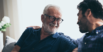 An elderly man and his son sit together