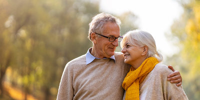 A retired couple walking outside in the fall
