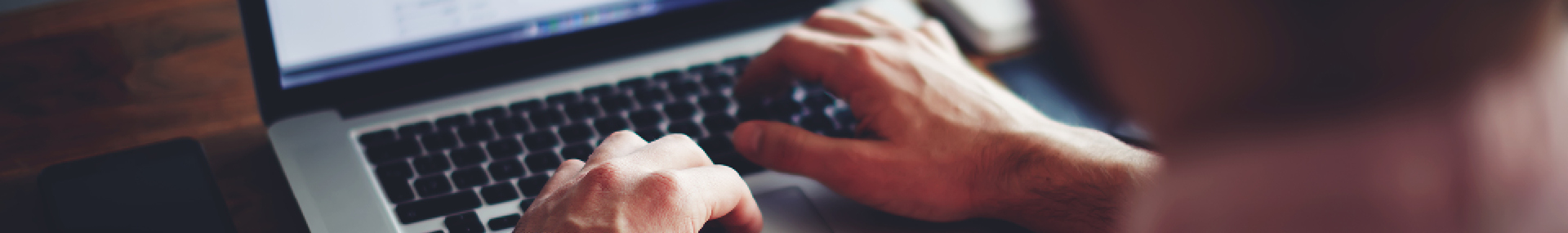 Man using laptop to report insurance fraud online.