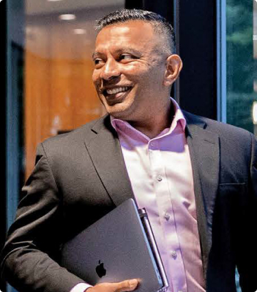 A smiling Protective teammate stepping out of an office.