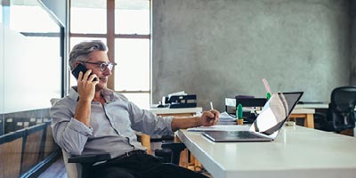 Man on phone looking at computer