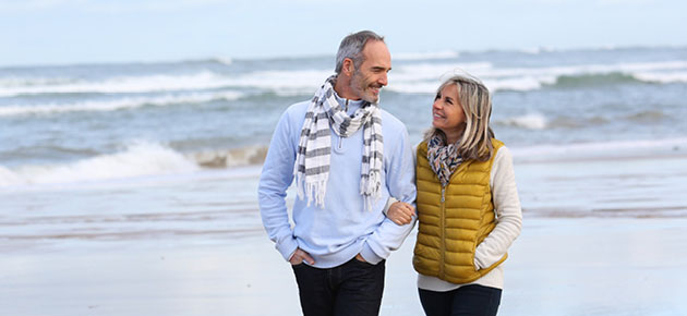 A middle age couple walks together on the beach
