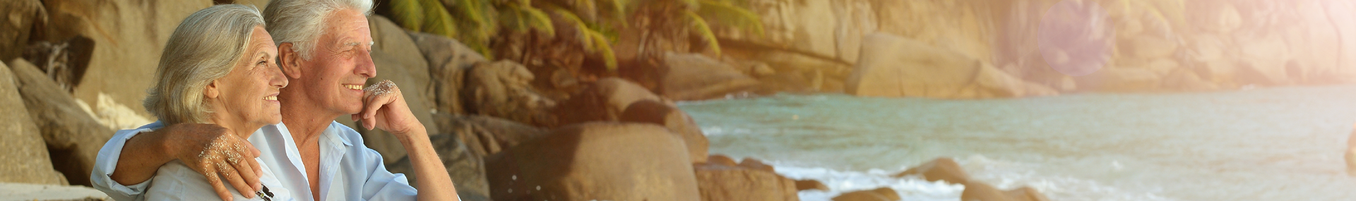 A senior couple embracing and overlooking the ocean.