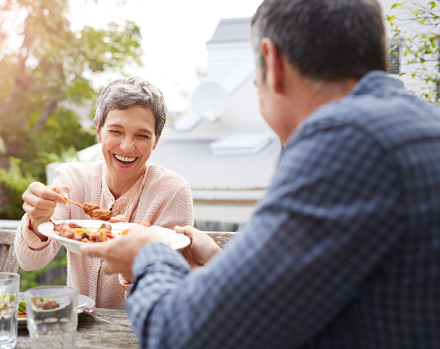 Older man and woman eating outside