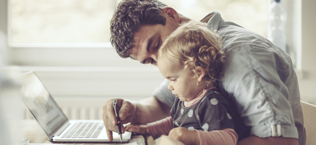 Father holding baby at computer