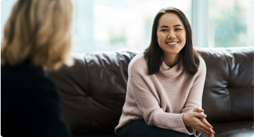 A smiling woman meeting with a mental health counselor.
