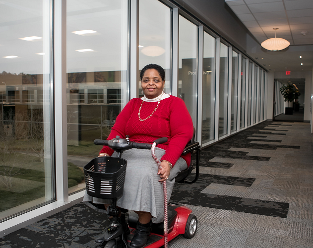 Female Protective employee using motorized wheelchair