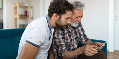 Father and son using a tablet to start a life insurance claim with Protective.