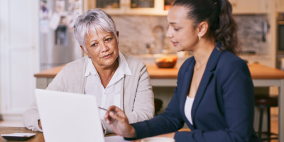 A financial professional using a computer to show an older woman Protective's claims resources.