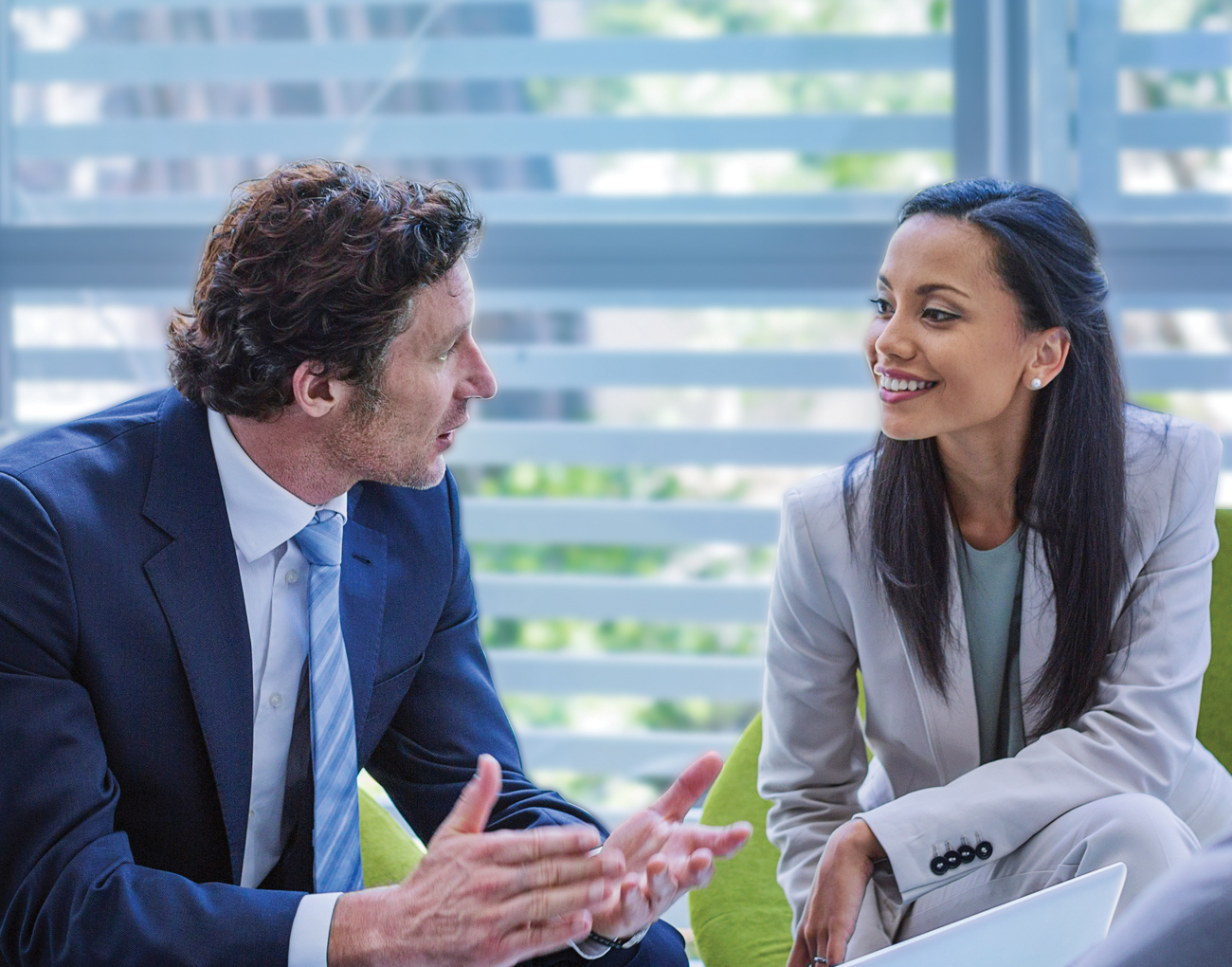 A man and a woman speak in an office.