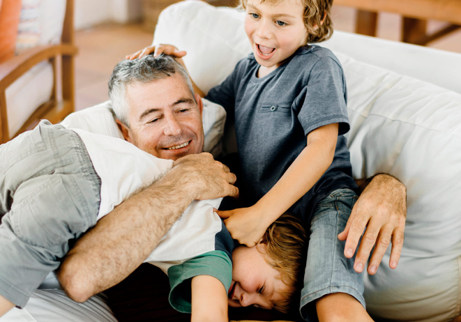 A man plays with his grandchildren.