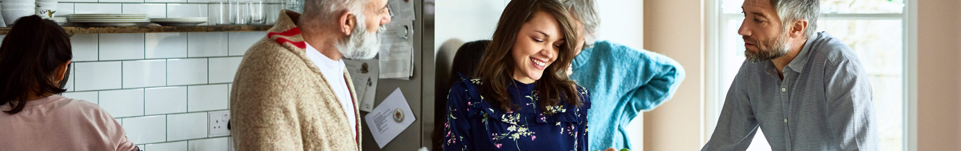 Five family members prepare a meal in a kitchen.