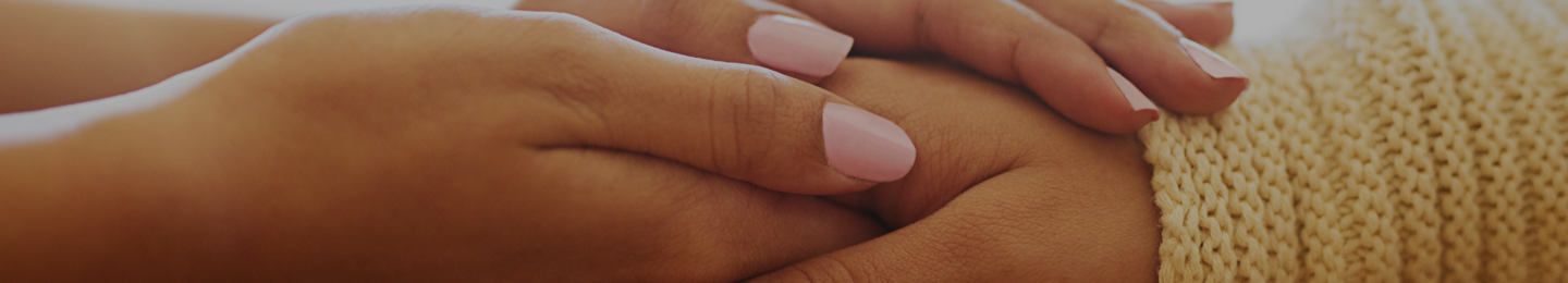 A woman's hands holding another's for comfort.