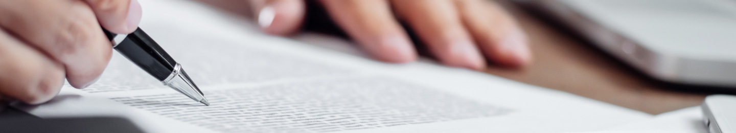 Hands holding a pen and reviewing a copy of Protective’s Code of Business Conduct.