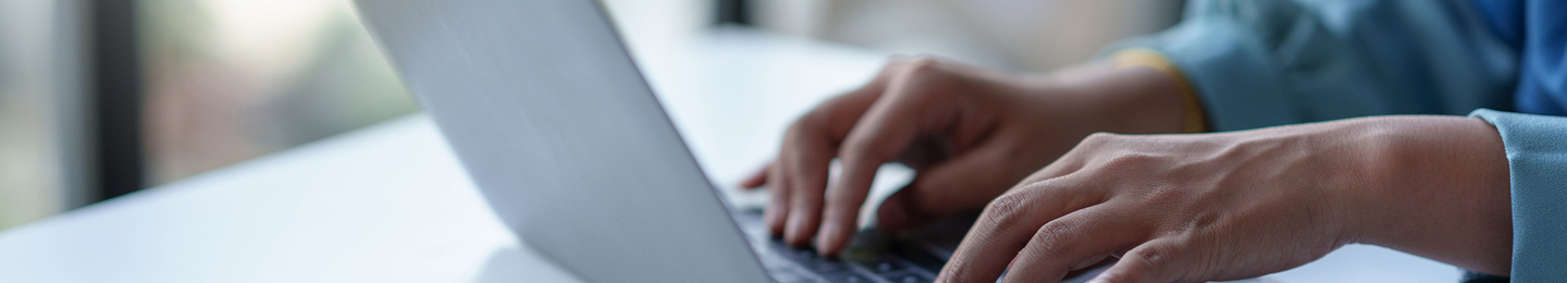 A close up of a person using a laptop to review fund performance information.