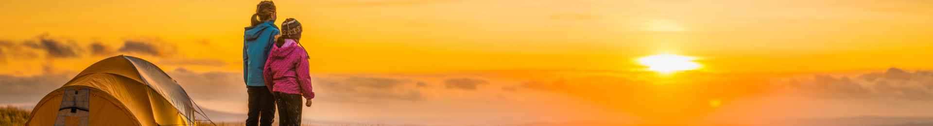 Young girls camping and watching the sunset