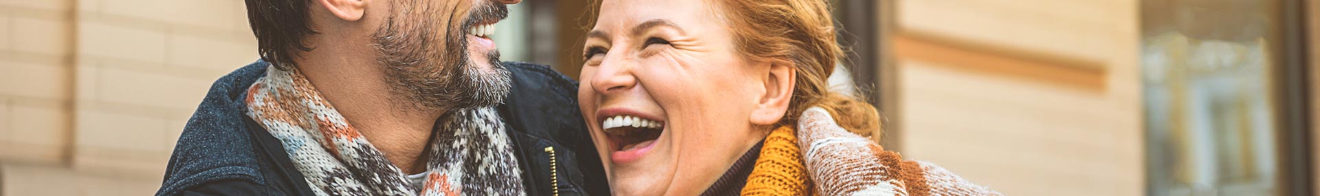 Happy couple laughs together while walking down the street in a city