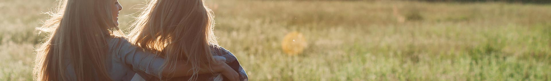 Two women walk together through a field