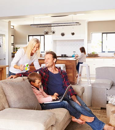 Family sitting in living room with a laptop