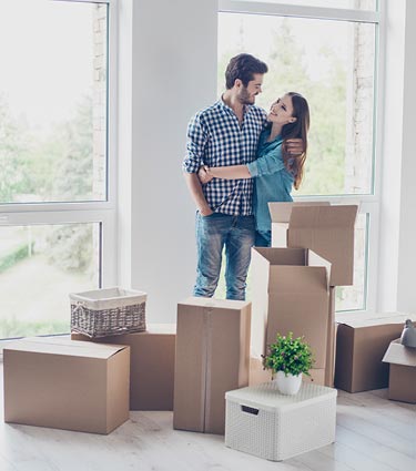 Young couple surrounded by moving boxes in new home