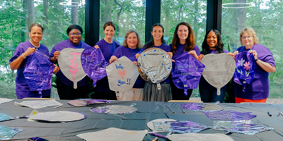 Smiling Protective employees holding balloons with handwritten encouraging messages
