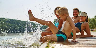 Young family with two children at lake having fun