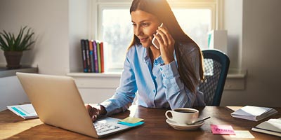 Woman on phone and computer trying to research if she can get affordable life insurance as a diabetic