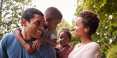 Successful family in park exploring whether they now need multiple life insurance policies