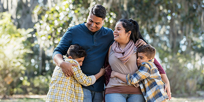 Hispanic family with 2 young boys enjoying time outside together