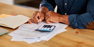 Man using calculator to determine the cost of term life insurance.