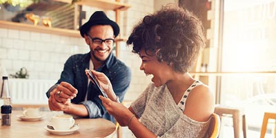 Millennials laughing over coffee, symbolizing a generation that should consider buying life insurance