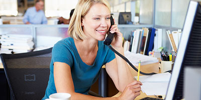 Woman at her work desk talking on the phone.