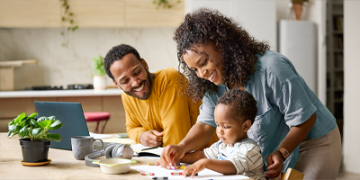 African American mom and dad teaching their toddler at a table