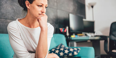 Concerned woman looking as though she may face uncertainties and may need critical illness or disability insurance.