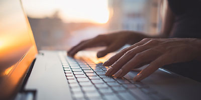  Hands on a laptop keyboard researching what the definition of the various roles in a life insurance policy are.