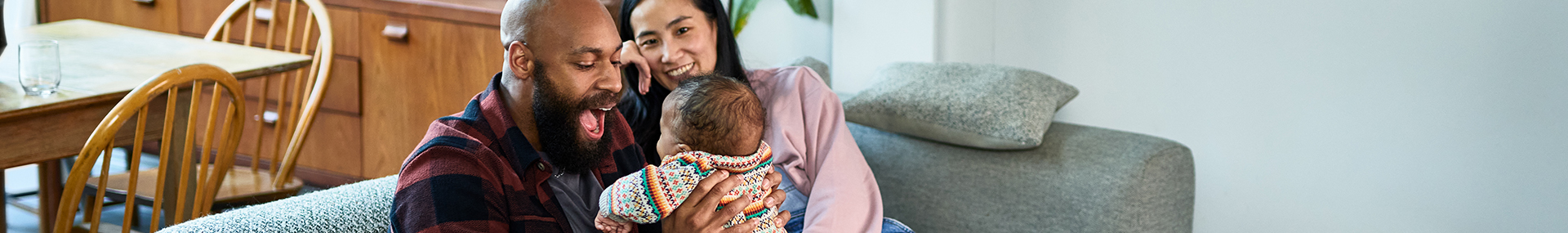 Woman and man holding a baby representing a family who might consider universal life insurance vs. term life insurance.