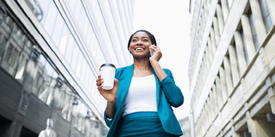 Young businesswoman talking on the phone with a Protective Life insurance agent discussing her life insurance options. 